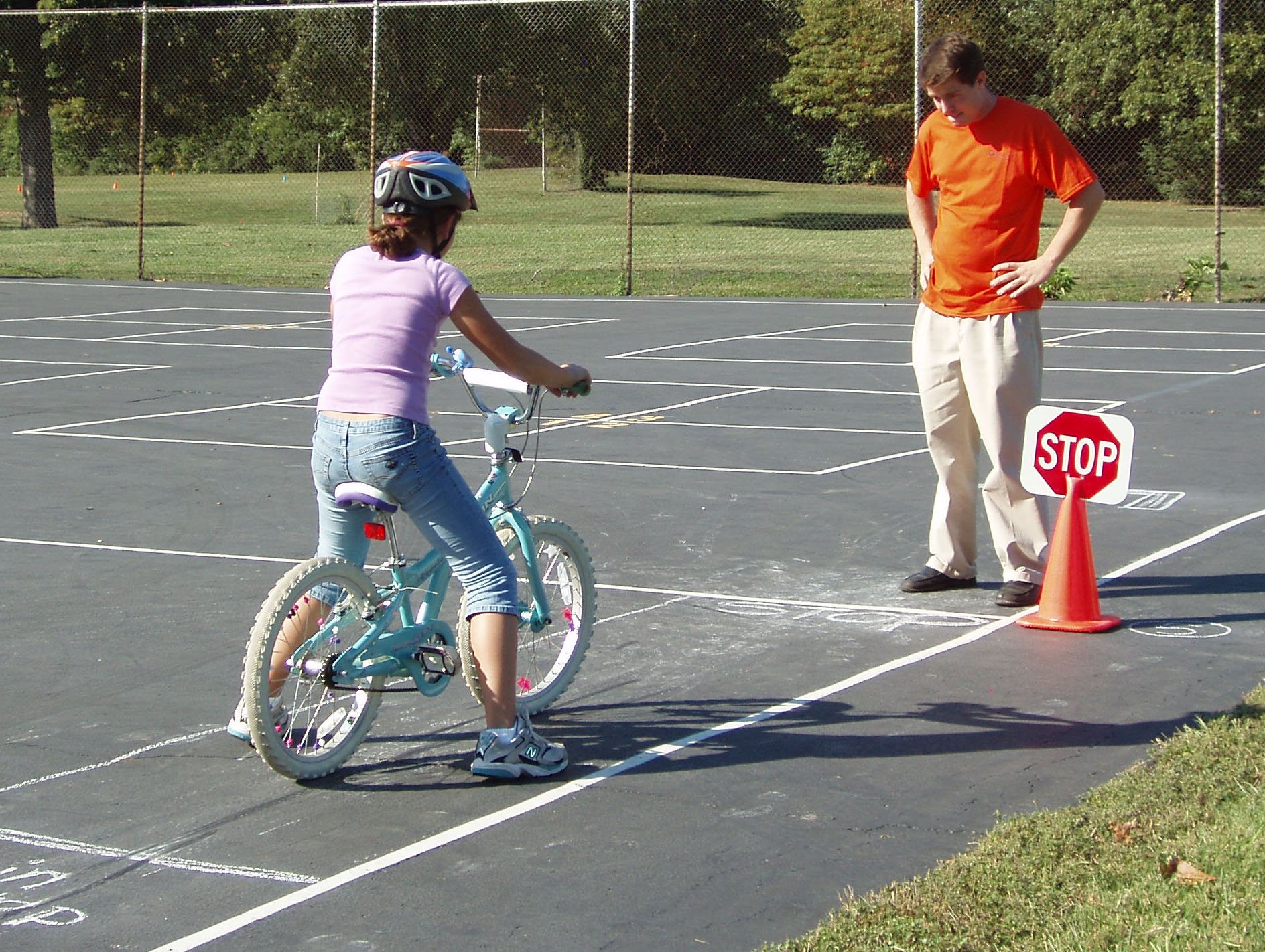 Children practicing bike handling skills near cones at a safety event.