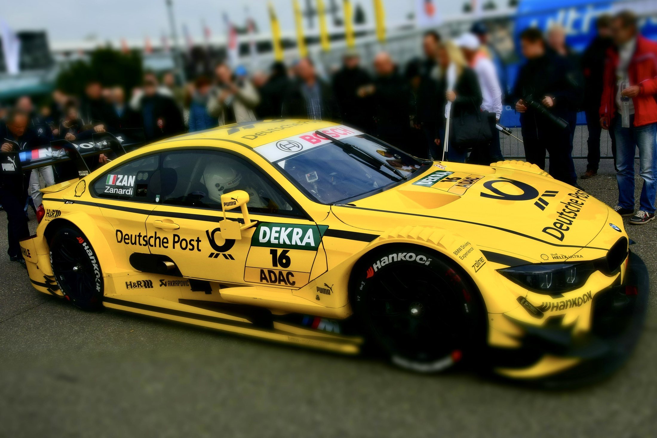 A bright race car driving on a track.