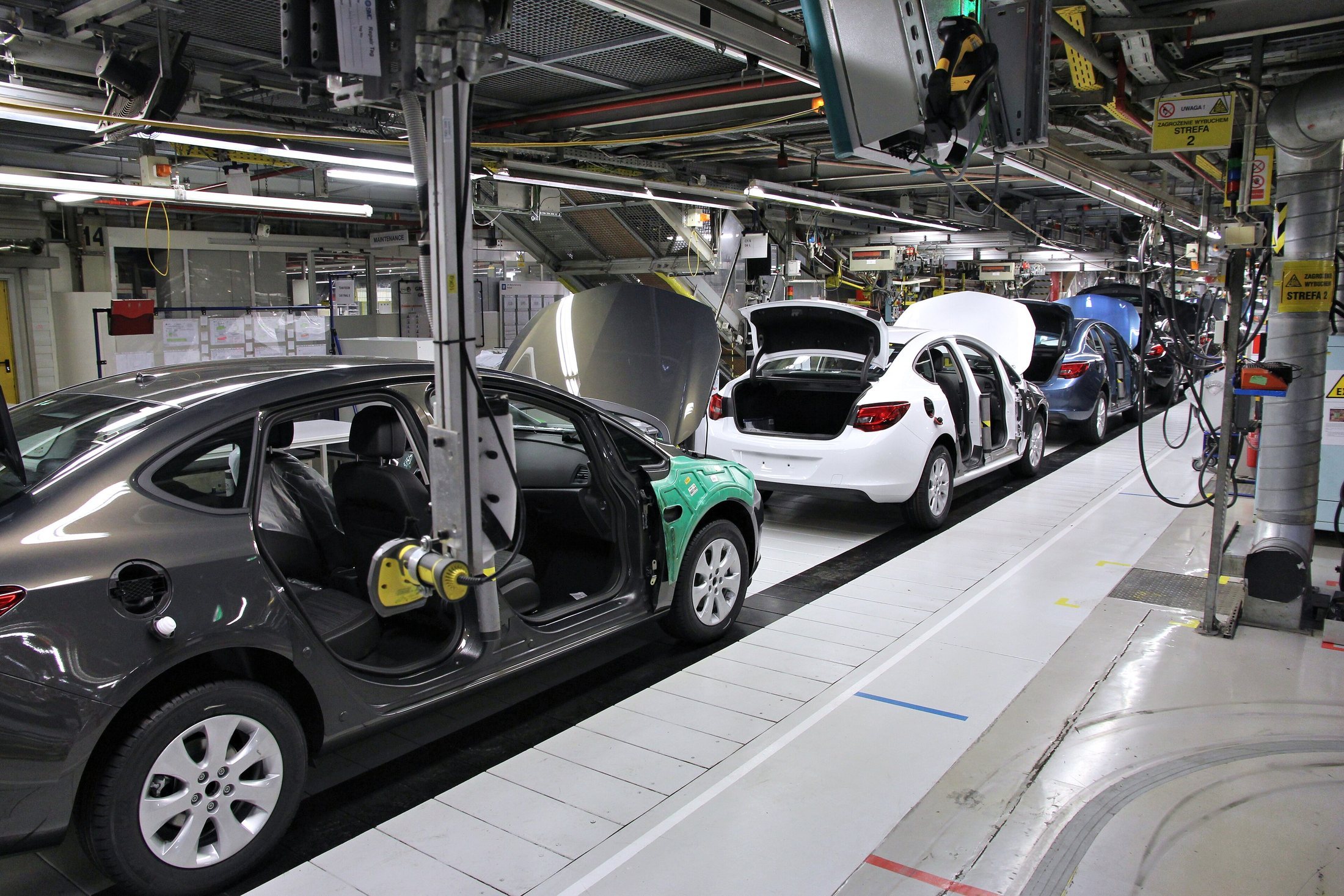 Cars being built on a factory assembly line.