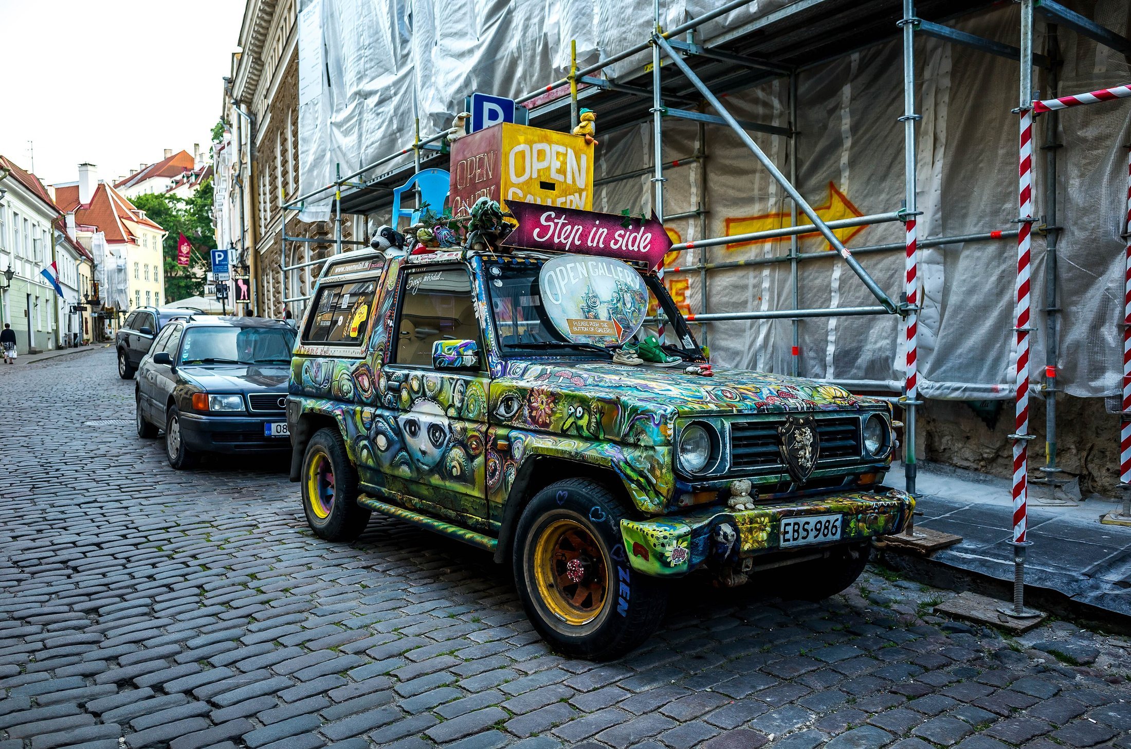 A brightly painted four-wheel-drive car with many colors.