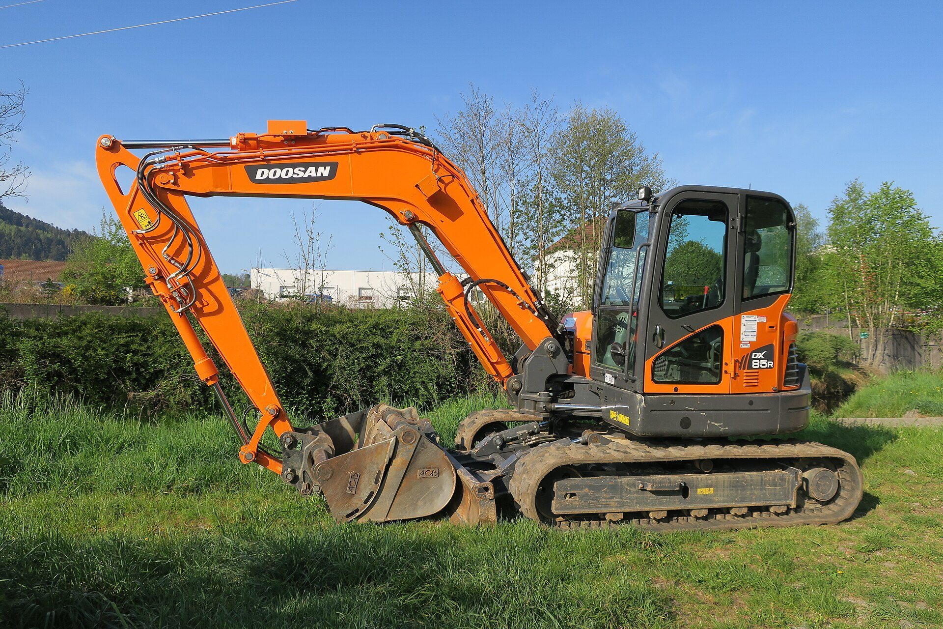 A Doosan excavator showing its boom, arm, and bucket extended outward