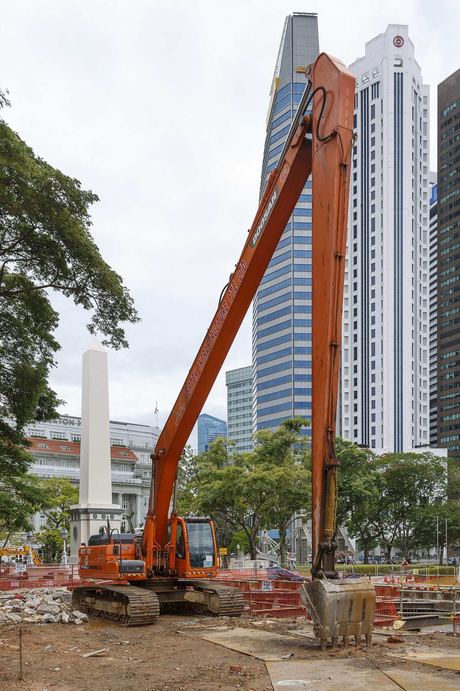 A tall Doosan excavator with a long-reach boom at a city construction site in Singapore