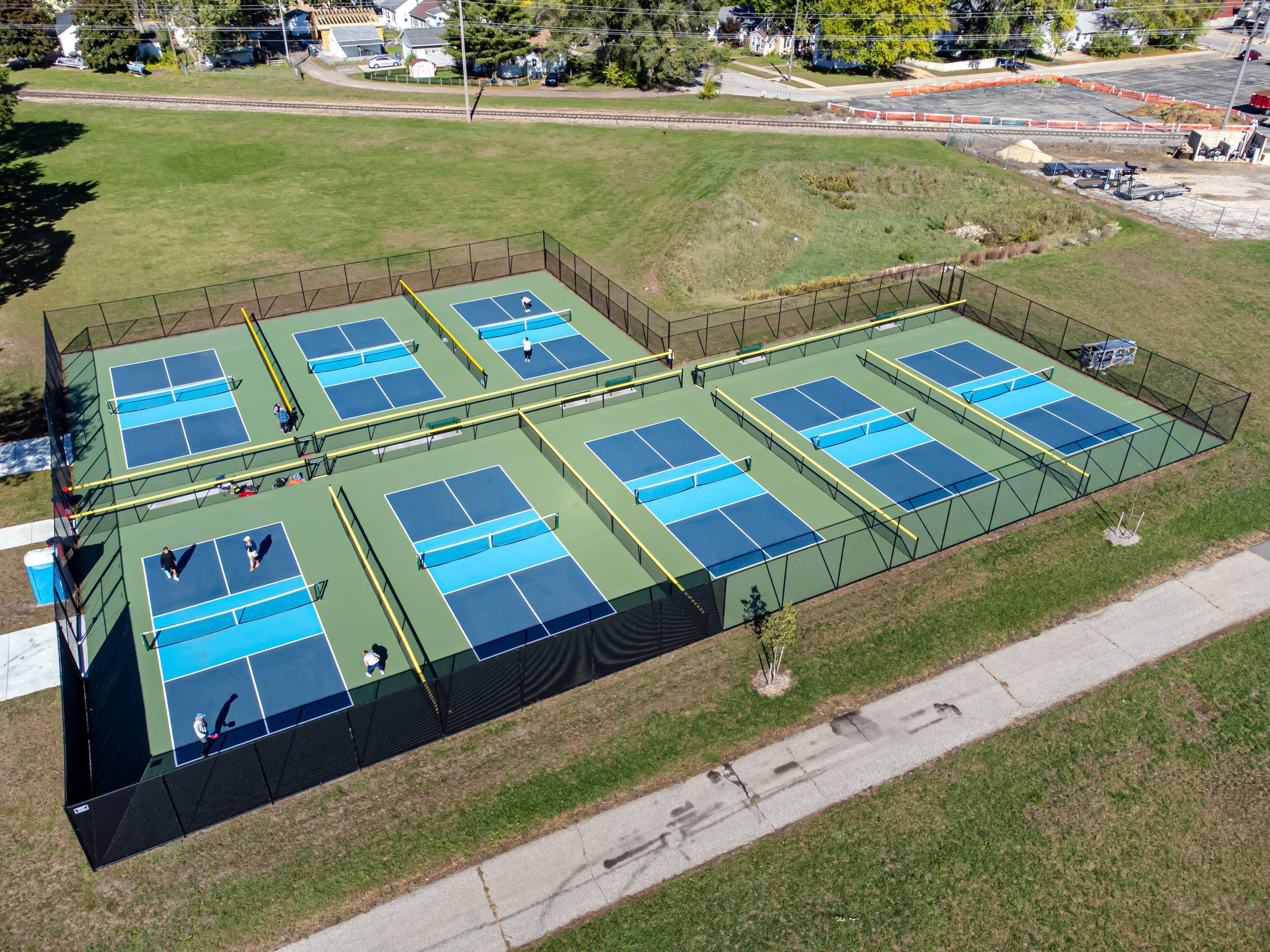 Aerial view of outdoor pickleball courts with players in La Crosse, Wisconsin, showing the court lines and net