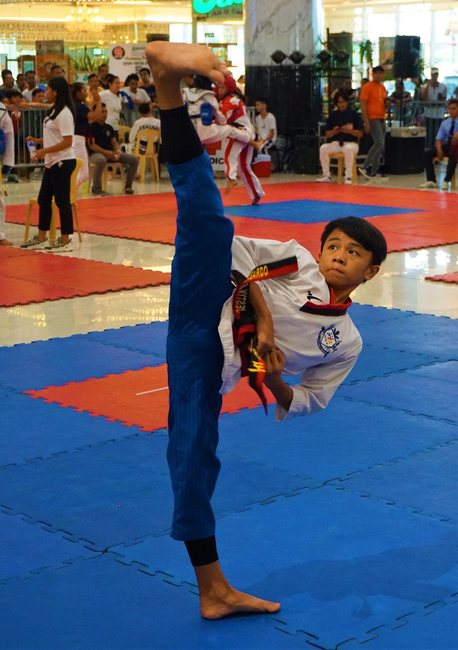 A young taekwondo student performing a form during a local tournament.