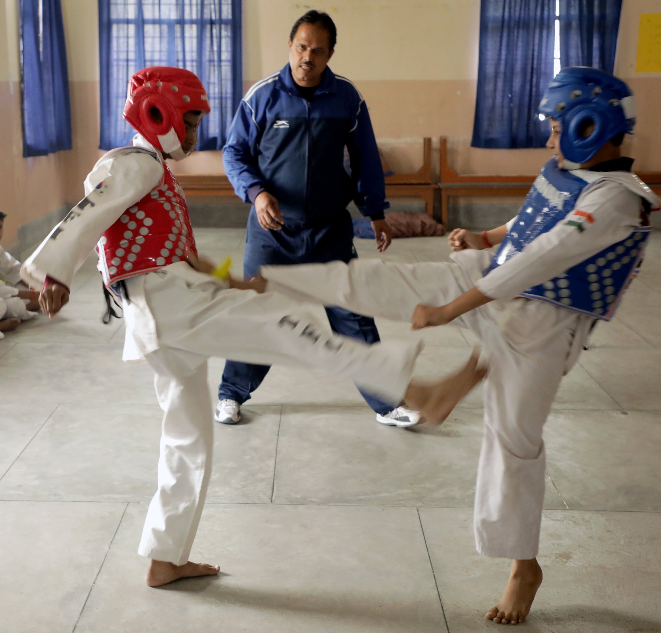 Taekwondo students wearing protective headgear during class.